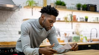 man in kitchen opening mail ecOhBNj.width .jpg