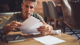 man with bills at desk fggd.width .jpg