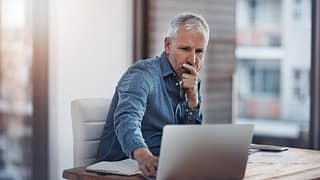 older man denim shirt laptop gettyimages .jpg