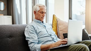 older man on laptop on couch gettyimages .jpg