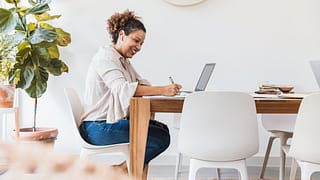 person at dining table writing in notebook TR.width .jpg