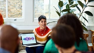 person leading meeting in office with laptop .width .jpg