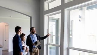 realtor with couple in house KoSQxI.width .jpg