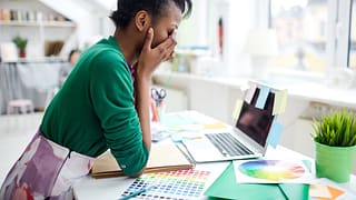 stressed young woman sitting at desk in front.width XQyxeQY.jpg