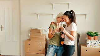 two people with champagne and moving boxes T.width .jpg