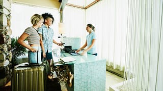 two women checking into hotel VFnxxdU.width .jpg