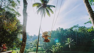 woman on swing in tropical vacation.width .jpg