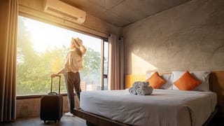 woman with suticase at hotel room window.width .jpg