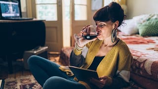woman with wine watching movie on tablet.width .jpg