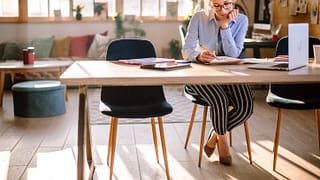 woman writing in notebook at desk near laptop.width OXuOD.jpg