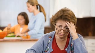 worried senior woman holding checkbook.jpg