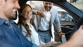 Car salesman assisting coupe with car purchas.width aDiU.jpg