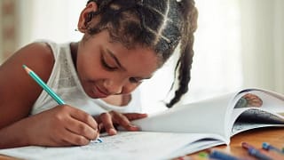 Child coloring in activity book. LGCfO.width .jpg