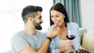 Couple eating chocolates and drinking wine to.width .jpg