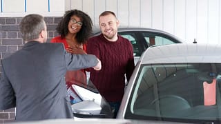 Couple shakes hand with a car salesman near a.width DnSBi.jpg