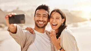Couple smiling and taking selfie with engagem.width .jpg