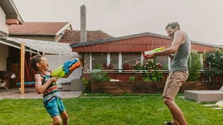 Man and child play with squirt guns in homes .width qPwAKO.jpg