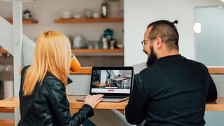 Man and woman look at homes on a laptop ezCl.width .jpg