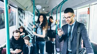 People on a bus with several using their cell.width EBrObLs.jpg