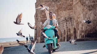Tourists riding motorized scooter in old euro.width DbAtPjZ.jpg