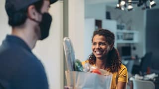 Woman accepting a delivery of groceries. EZB.width .jpg