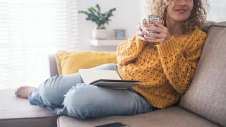 Woman drinking coffee on couch GTFVC.width .jpg