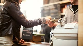 Woman paying for purchase with cash. VMjwvr.width .jpg