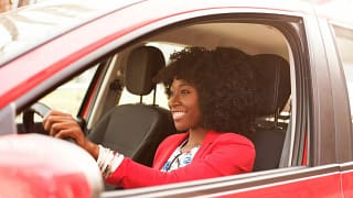 Woman smiling as she drives a red vehicle Db.width .jpg
