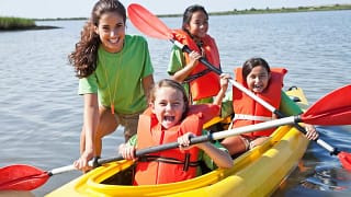 Young adult girl helping kids in a kayak FaRw.width .jpg