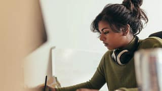 Young woman writing with headphones rJQSmvR.width .jpg