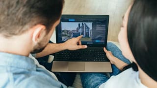 couple looking at house on laptop.width .jpg