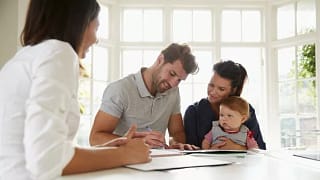 couple with baby signing house closing docume.width .jpg