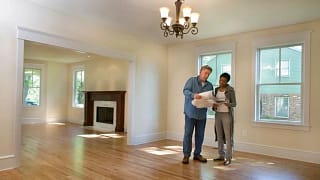 man and woman with blueprints in empty house .width .jpg