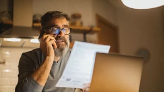 man on phone with paper and laptop KarxXs.width .jpg