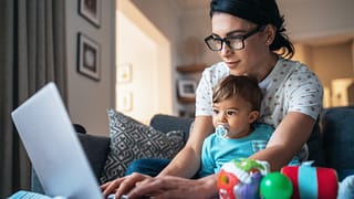 person using laptop with baby in front of them.jpg