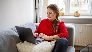 person on couch with laptop NhPfiGo.width .jpg