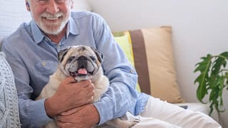 smiling person holding dog gettyimages .jpg