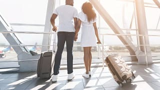 two people with suitcases holding hands hNDS.width .jpg