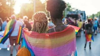 two women in rainbow flag at parade.width .jpg