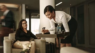 waitress and customer in airport lounge fc.width .jpg