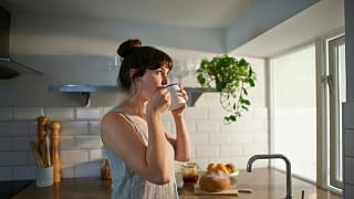 woman drinking tea in kitchen fauhDGH.width .jpg
