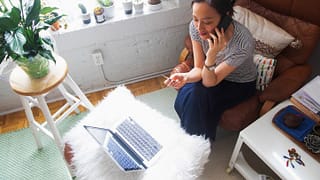 woman on phone with credit card and laptop y.width .jpg