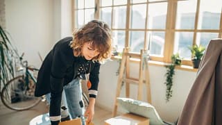 woman packing moving boxes in apartment Pedi.width .jpg