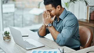 young man stressed laptop a person at a laptop putting their hands on their face and closing their eyes gettyimages .jpg
