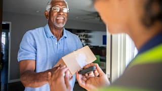Man accepting package from a delivery driver .width .jpg