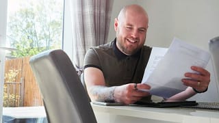Man smiling reading a letter rvqbJE.width .jpg