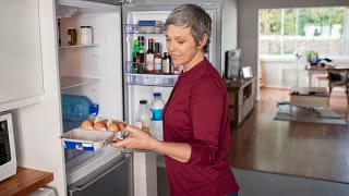 Woman opening refrigerator ymOwHf.width .jpg