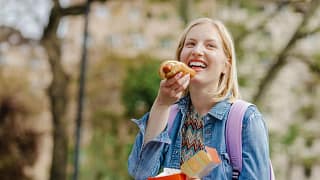 Young woman eating a hotdog snzotnb.width .jpg