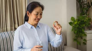 asian woman holding a pill.jpg