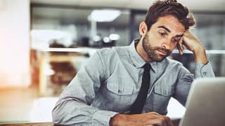 bored man working at computer at office job.width .jpg